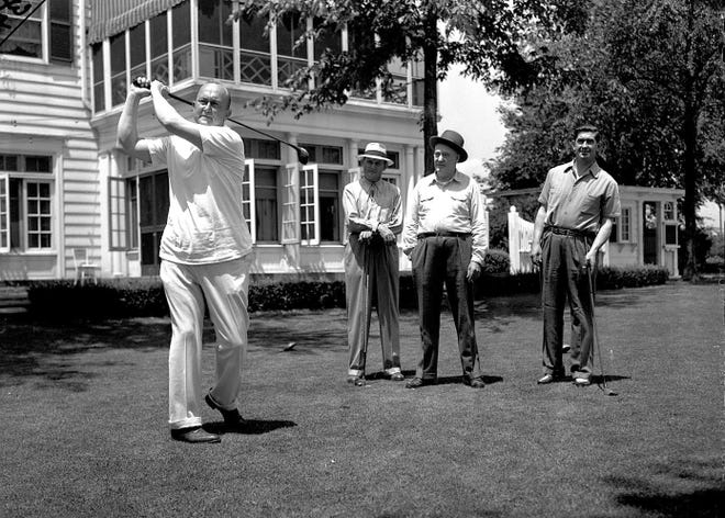 Former Tiger Ty Cobb swings a golf club at Oakland Hills Country Club in Bloomfield Hills. With him is fellow Tiger Gordon "Mickey" Cochrane, right. The others are M.E. Coyle and Al Watrous, the club pro.