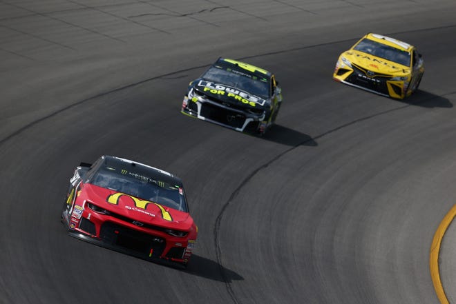 Jamie McMurray, driver of the No. 1 Chevrolet, leads Jimmie Johnson and Daniel Suarez during the NASCAR Cup Series Consumers Energy 400 at Michigan International Speedway.