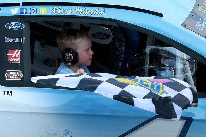 Keelan Harvick, son of Kevin Harvick, celebrates with the checkered flag after his dad won the NASCAR Cup Series Consumers Energy 400 at Michigan International Speedway.