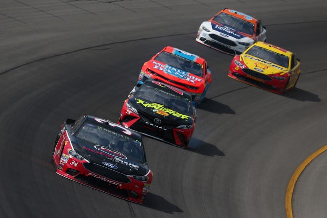 Michael McDowell, driver of the No. 34 Ford, leads a pack of cars during the NASCAR Cup Series Consumers Energy 400 at Michigan International Speedway.