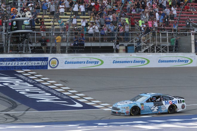 Kevin Harvick sits on the finish line after winning the NASCAR Cup Series Consumers Energy 400 at Michigan International Speedway.