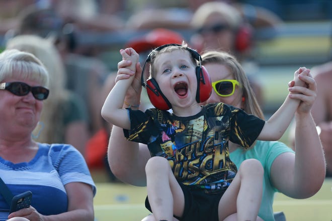 A young fan cheers during the NASCAR Cup Series Consumers Energy 400 at Michigan International Speedway.