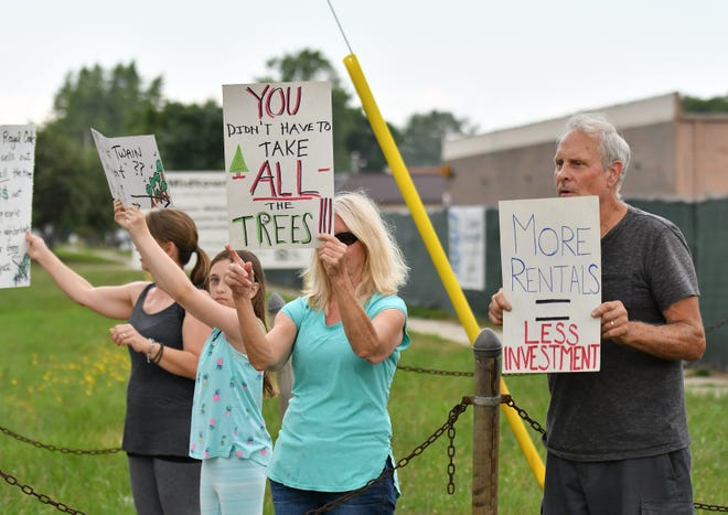 Jack Wall of Royal Oak, right, stands with other residents protesting in front of a construction site on Campbell Road just south of W. Fourteen Mile Road in Royal Oak on Aug. 8.