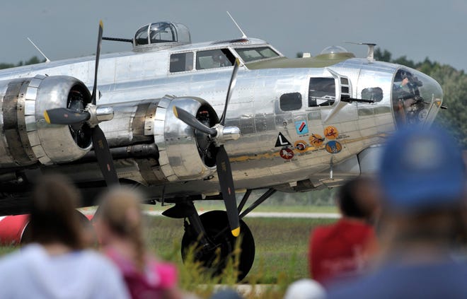 A Boeing B-17 Flying Fortress strategic bomber taxis past the crowd.