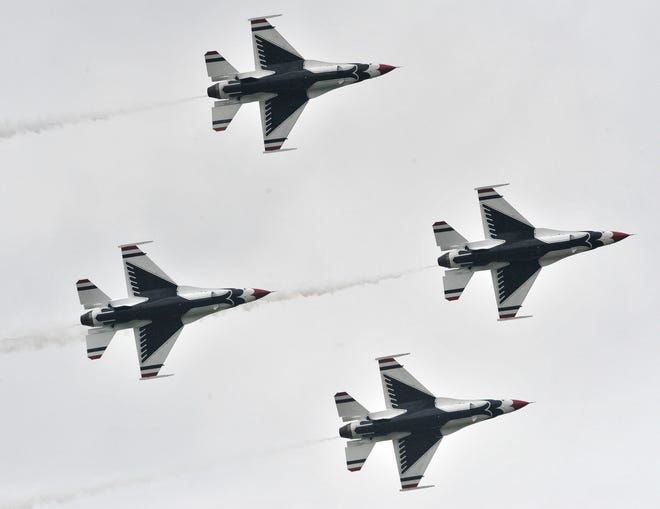 The U.S. Air Force Thunderbirds perform maneuvers in their F-16 Fighting Falcon fighter jets over the airfield.
