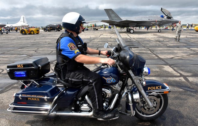 Detroit Metro Airport / Willow Run Airport Police Corporal Kristopher Meyers secures this area as military personnel escort one of two F-35A jets to its viewing area. The F-35As are stationed at Eglin Air Force base in Florida.