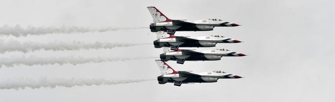 The U.S. Air Force Thunderbirds perform maneuvers in their F-16 Fighting Falcon fighter jets over the airfield.