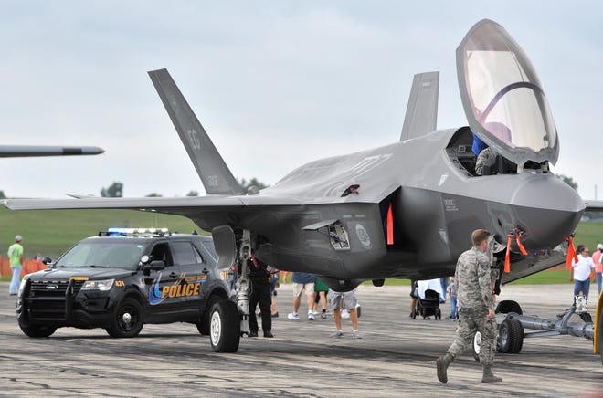 Military personnel escort one of two F-35A jets to its viewing area. The F-35As are stationed at Eglin Air Force base in Florida.