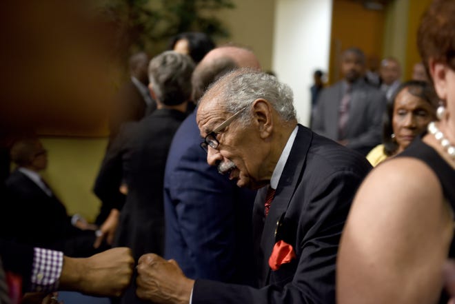 Former U.S. Congressman John Conyers gets a fist bump at the Aretha Franklin memorial at Greater Grace Temple.