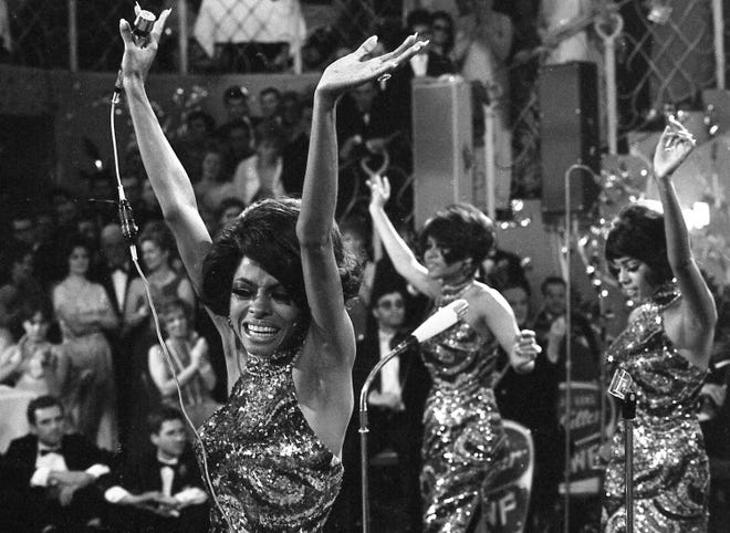 The Supremes with Diana Ross, front, Cindy Birdsong and Mary Wilson throw their arms in the air as they perform in Munich, West Germany, Jan. 21, 1968.