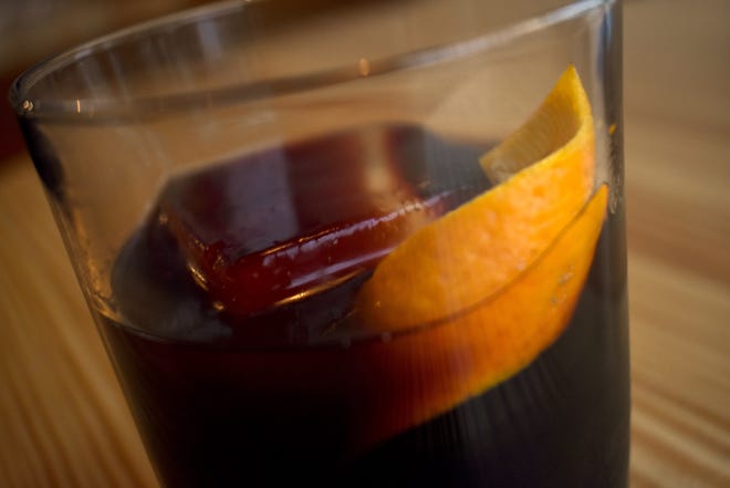 A new cocktail mixes mulled wine syrup with bourbon and cream de cassis; it is topped with an orange peel.