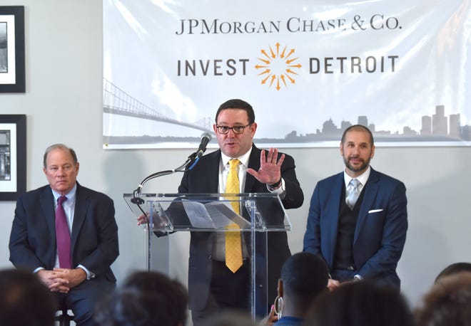 Peter Scher, center, head of corporate responsibility at JPMorgan Chase, announces a $15 investment in Detroit neighborhoods as Detroit Mayor Mike Duggan, left, and Invest Detroit CEO Dave Blaszkiewicz, right, listen.