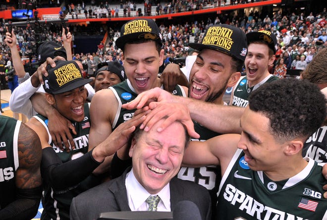The Spartans mess up coach Tom Izzo's hair in celebration as Michigan State  beats Louisville, 76-70, in their 2015 NCAA "Elite Eight" game in Syracuse, N.Y.