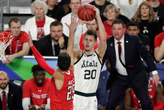 Michigan State guard Matt McQuaid (20) shoots over Texas Tech guard Davide Moretti during the first half in the semifinals of the Final Four NCAA college basketball tournament, Saturday, April 6, 2019, in Minneapolis.