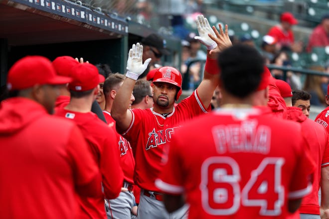 The Angels' Albert Pujols celebrates in the dugout after hitting a solo home run in the third inning.