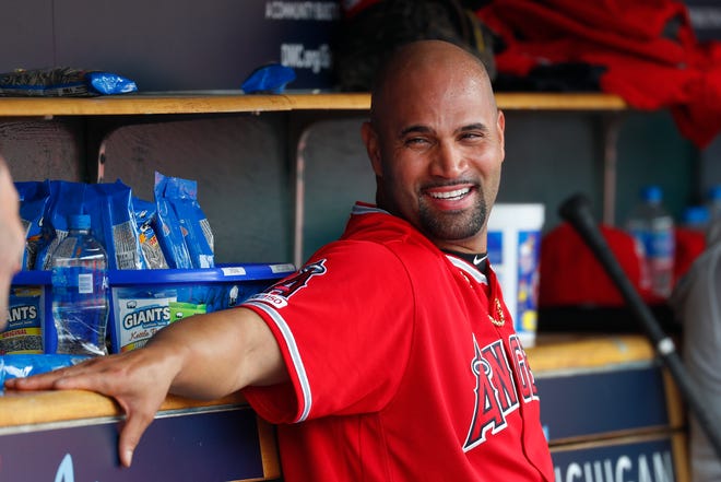 Los Angeles Angels' Albert Pujols smiles in the dugout after hitting a solo home run in the third inning that was his 2,000th career RBI.