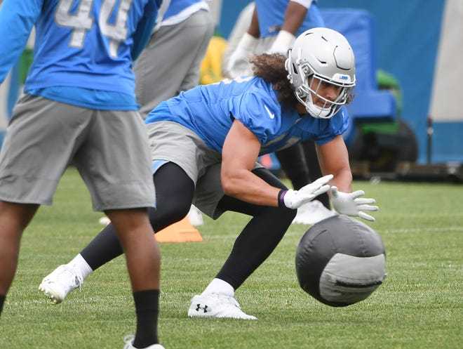 Lions linebacker Jahlani Tavai works with a heavy ball  during drills.