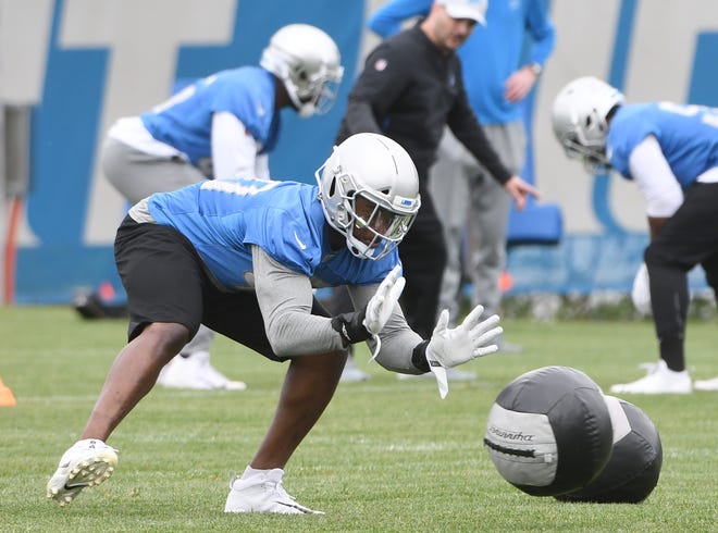 Lions linebacker Jarrad Davis works with a heavy ball  during drills.