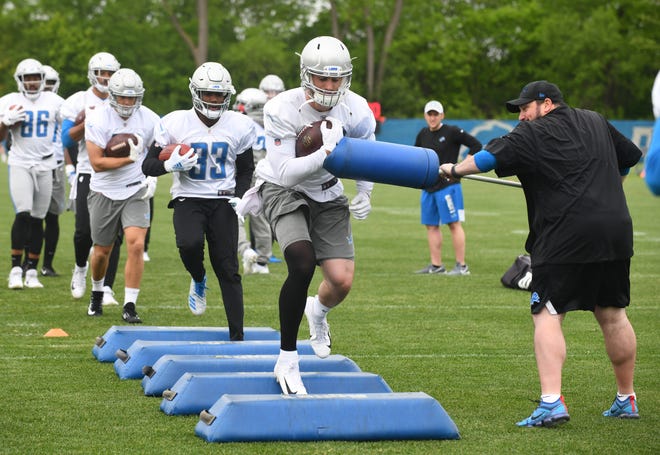 Detroit Lions tight end Jesse James works through obstacles with added pressure from head coach Matt Patricia during drills.