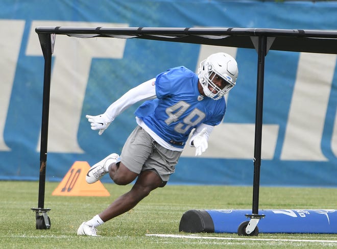 Lions linebacker Mark Thompson works under an obstacle during drills.