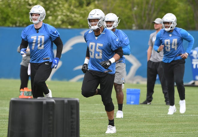 Lions defensive end Romeo Okwara jogs to the next drill during practice.