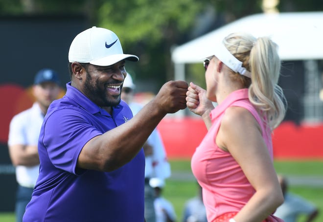 Jerome Bettis and Paige Spiranac bump fists after Bettis sinks his putt on 16.