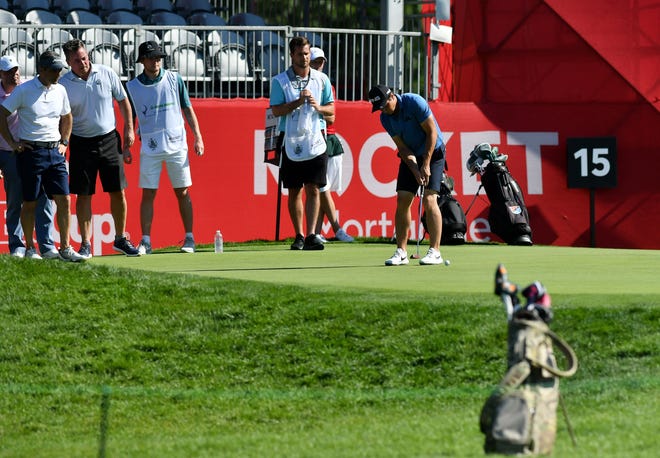 People in his group and caddies watch as Viktor Hovland, one of the newest members of the PGA, putts on hole No. 15.