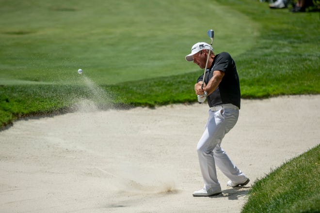 Alex Cejka hits out of the bunker on the 18th hole.