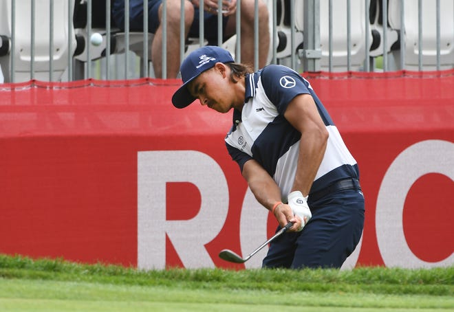 Rickie Fowler hits out of the rough along the 10th green.