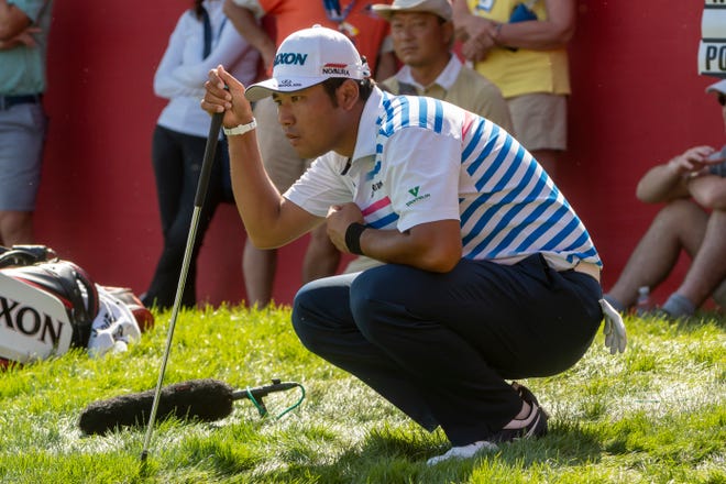Hideki Matsuyama lines up a putt on the 18th hole.