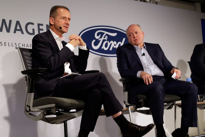 Volkswagen AG CEO Herbert Diess, left, and Ford Motor Co. CEO Jim Hackett  at  a news conference Friday in New York. The two automakers will to share electric vehicle platforms and self-driving software, potentially saving each company hundreds of millions of dollars.