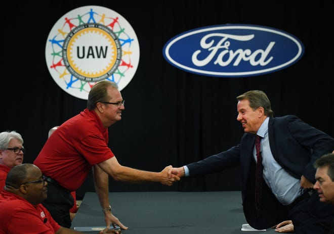 United Auto Workers President Gary Jones, left, and Ford Executive Chairman Bill Ford Jr.  shake hands to open contract negotiations Monday at Ford headquarters.