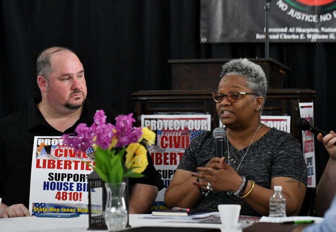 State Rep. Isaac Robinson, left, listens while Tawana Petty of Detroit Community Technology Project speaks at a town hall meeting discussing the use of facial recognition software by law enforcement.