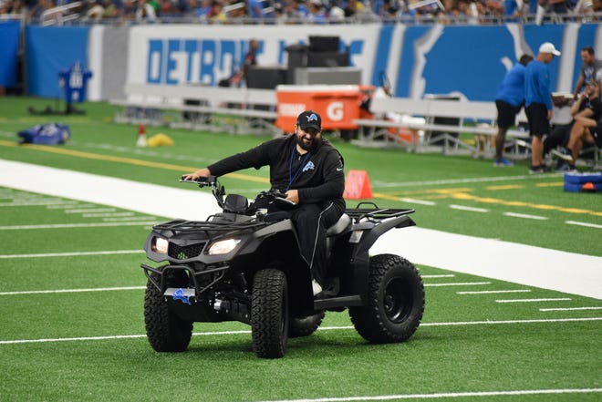 Lions head coach Matt Patricia smiles as he drives his ATV onto the field for media interviews during Friday ' s open practice session.