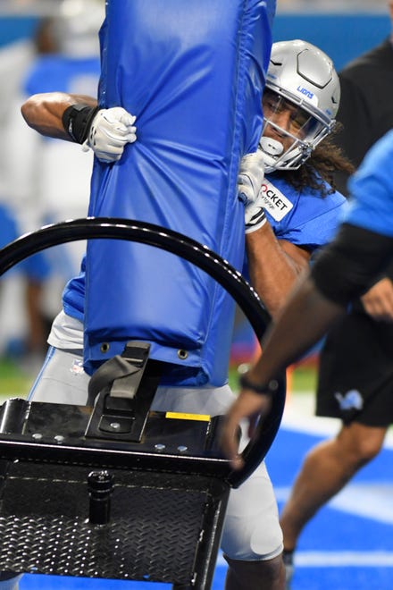 Lions rookie linebacker Jahlani Tavai hits a tackling dummy during the open practice session at Lions Family Fest.