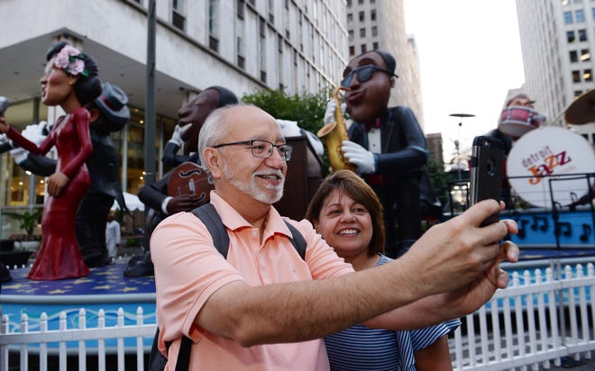 Carlos and Millie Bueno of Pontiac takes a selfie with Jazz Festivals mannequins.