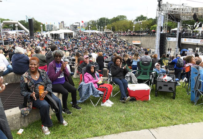 People watch a big screen that shows Thornetta Davis performing on the Carhartt Ampitheater Stage.