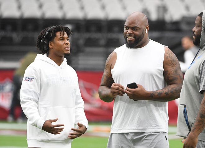 Former Lion Charles Washington, now a  safety with the Cardinals, chats with the Lions' A'Shawn Robinson before the game.