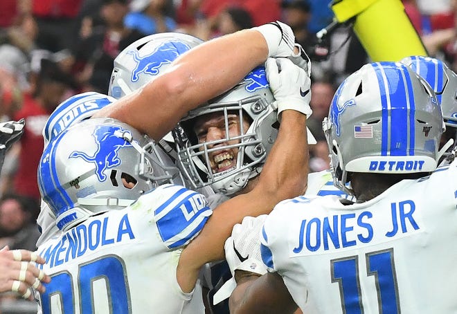 Lions players mob T.J. Hockenson after his first NFL touchdown at the start of the fourth quarter.