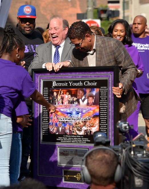 Detroit Mayor Mike Duggan, center, presents the key to the city to the choir and choir director Anthony White, left.
