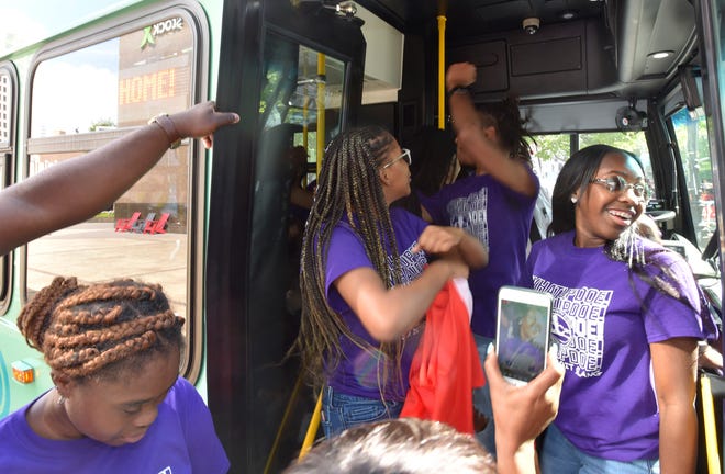Members of the Detroit Youth Choir and support staff disembark from one of two D-DOT buses that transported the choir to Campus Martius.