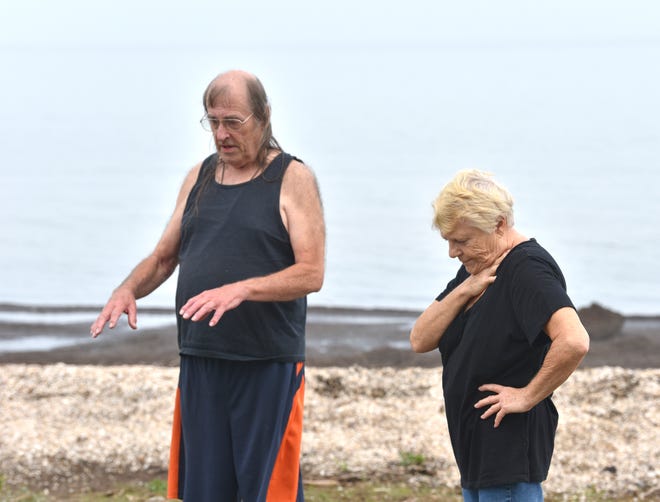 Bill Thorson, 76, and Jean Tude Thuot, 74, of Bangor Township, talk about the rising Saginaw Bay waters behind their Bayshore Drive houses.