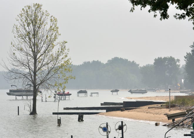 A tree stands in the water of Saginaw Bay at Killarney Beach in Bangor Township. Residents have seen their backyard beaches diminish in recent years.