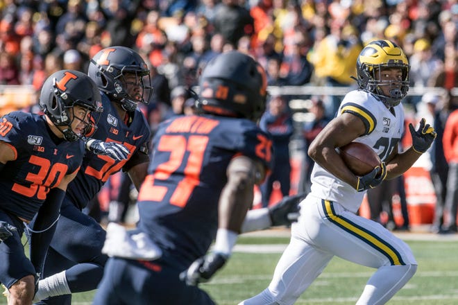 Michigan's Hassan Haskins runs away from the Illinois defense to score a touchdown last week.