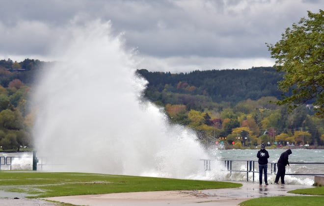 High water in Grand Traverse Bay, fed by winds on Lake Michigan, splashes onto the lawn at the Open Space in downtown Traverse City on Oct. 16.