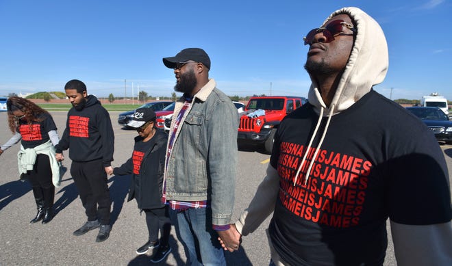 Joseph White, left, of Wayne, puts his head back as K.C. Pierce, III, second from right, pastor of Hopewell Baptist Church and chairman of religious affairs for the NAACP-Detroit Branch, prays before the crew marches to Beaumont Hospital on Oakwood.