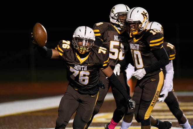 North Farmington linebacker Andrew Dooley (76) celebrates after scoring a touchdown on a blocked punt against Farmington in the first quarter.