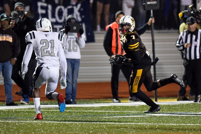 North Farmington wide receiver Eddie Lenton, right, runs for yards after the catch as he is chased by Farmington defensive back Julian Ama (21) in the first quarter on Friday, Oct. 18, 2019 in a game played at North Farmington High in Farmington Hills, Mich.