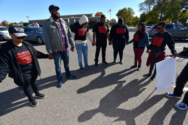K.C. Pierce III, second from left, pastor of Hopewell Baptist Church and chairman of religious affairs for the NAACP-Detroit Branch, prays before the crew marches to Beaumont Hospital on Oakwood.