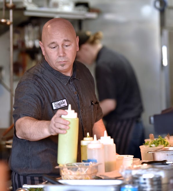 Co-owner / Chef Shawn Mckerness prepares food in his open kitchen.